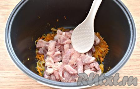 Затем в чашу мультиварки к обжаренным морковке и луку выкладываем кусочки свинины, обваленные в муке, обжариваем овощи с мясом минут 5-7, иногда помешивая.