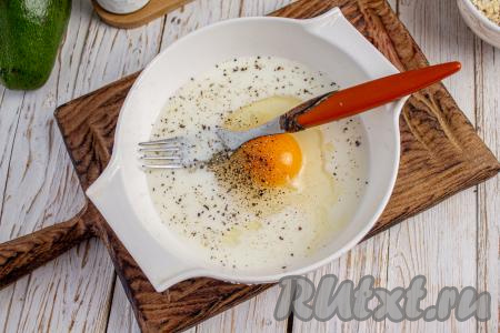 В миску вбейте яйцо, влейте молоко, посолите и поперчите по вкусу, перемешайте молочно-яичную массу вилкой.