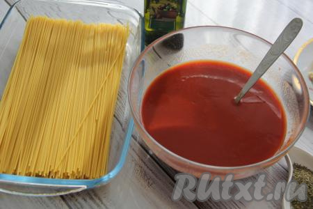 Сухие спагетти выложить в жаропрочную форму.  В отдельной миске соединить воду, томатную пасту и соль, хорошо перемешать получившийся томатный соус.