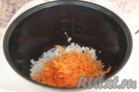 Обжарить лук 2-3 минуты, иногда его перемешивая. Затем добавить в чашу мультиварки натёртую морковку, обжаривать овощи ещё 4-5 минут (до мягкости), не забывая время от времени помешивать.
