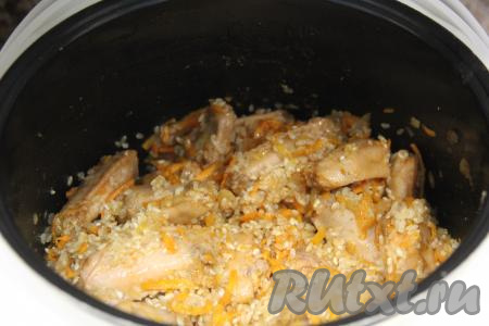 Перемешать рис с куриными крылышками в чаше мультиварки, добавить немного соли.