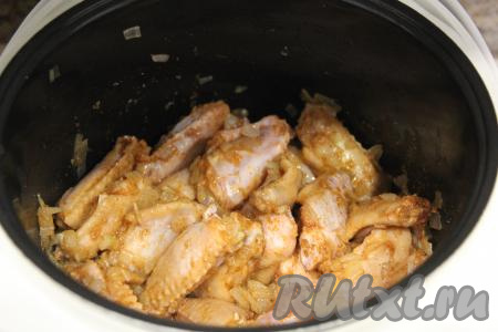 Обжаривать куриные крылышки с луком минут 10, периодически перемешивая.