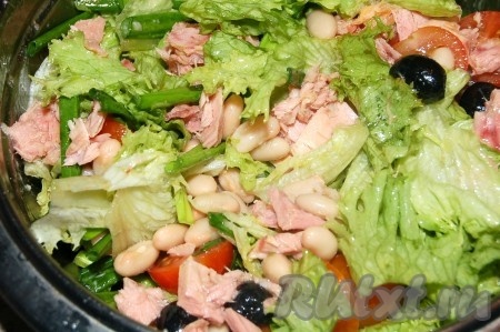 Выложить в салат кусочки консервированного тунца и очень аккуратно перемешать, стараясь оставлять кусочки рыбы целыми.
