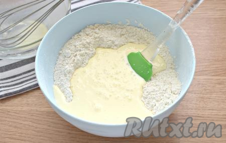 В миску со смесью сухих ингредиентов вливаем молочно-масляную смесь, тщательно перемешиваем тесто лопаткой.