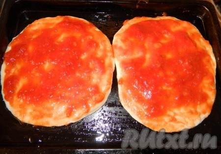 Перекладываем тесто для пиццы на противень, смазанный маслом. На тесто намазываем приготовленный соус из помидоров. И отправляем в разогретую духовку при температуре 220 градусов на 15 минут.

