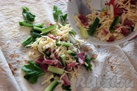 На лаваш выложить листовой салат и начинку.