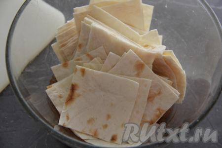 Выложить нарезанный лаваш в миску со смесью масла, паприки и соли, тщательно перемешать. Кусочки лаваша должны покрыться пряным маслом со всех сторон. 