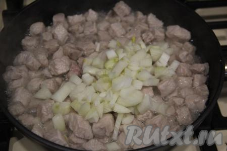 Обжарить кусочки мяса в течение 10 минут на среднем огне, периодически их перемешивая. Затем добавить в сковороду очищенную и мелко нарезанную луковицу, перемешать с мясом.
