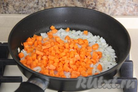 К обжаренному луку выложить нарезанную на мелкие кубики морковку, обжаривать овощи минут 5-6, периодически их перемешивая.