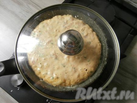 Накрыть сковороду крышкой и готовить пирог с курицей на самом маленьком огне 20 минут.