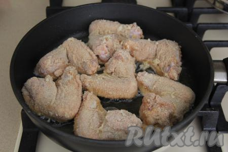 Выложить крылышки в двойной панировке в сковороду с разогретым растительным маслом.