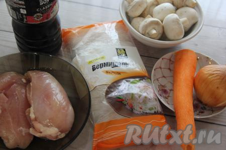Подготовить продукты для приготовления фунчозы с курицей, овощами и грибами. Лук и морковку очистить, шампиньоны и куриное филе промыть.