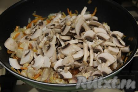 Обжаривать курицу с овощами минут 5, а затем добавить шампиньоны, нарезанные на пластины. Жарить курицу с овощами и грибами минут 15, периодически перемешивая.