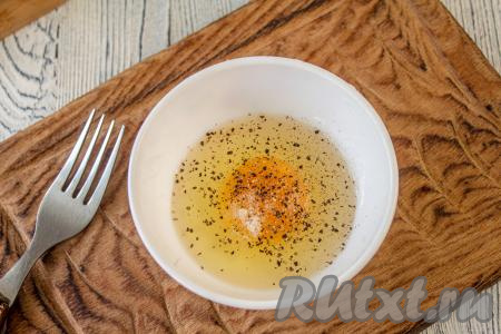 Пока варится рис, приготовьте яичные блинчики. Для этого одно яйцо вбейте в мисочку, посолите, поперчите и хорошо перемешайте (разболтайте) вилкой.
