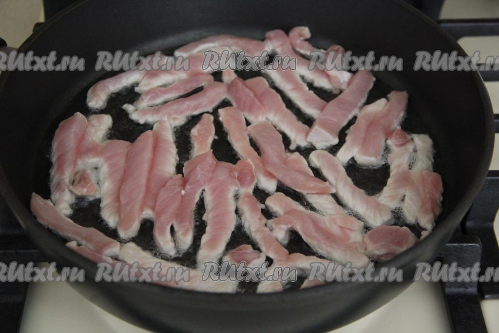 Свинину нарезать на длинные брусочки. Разогреть в сковороде растительное масло, затем выложить брусочки мяса в один слой, жарить на среднем огне.