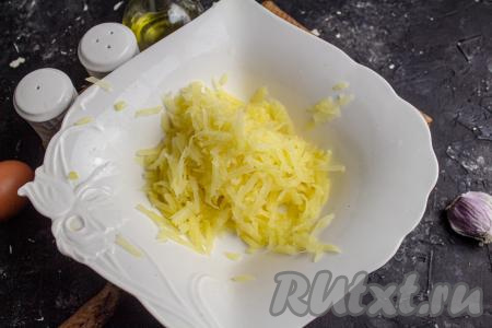 Картофель очистите, натрите на крупной тёрке и выложите в подходящую посуду. 