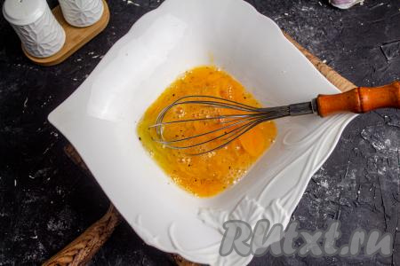 Вначале приготовим омлет, для этого в подходящую посуду вбейте куриные яйца и взбейте их венчиком. Посолите яичную смесь и поперчите по вкусу.