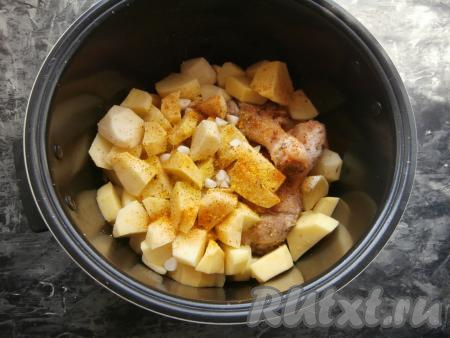 Далее добавить в чашу очищенный картофель, нарезанный на средние кусочки, измельчённый чеснок, посолить сверху, посыпать специями.