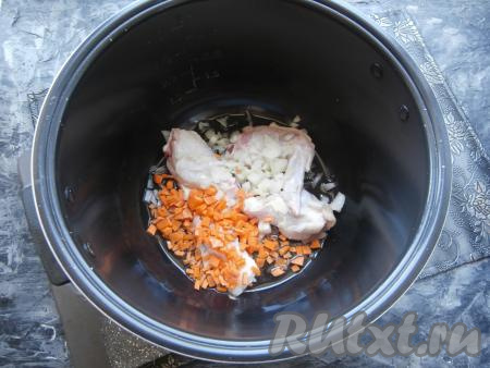 Лук, зубчик чеснока и морковку очистить. В чашу мультиварки налить растительное масло, выставить режим "Жарка" на 15 минут. Курицу вымыть, нарезать на части, выложить в чашу вместе с мелко нарезанными луком и морковкой.