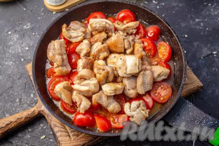 В сковороду с помидорами добавьте обжаренные кусочки курицы, перемешайте, доведите бульон до кипения, а затем тушите под крышкой на медленном огне 5 минут. 