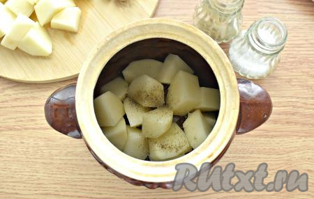 В горшочек выкладываем половину нарезанной картошки, немного солим и перчим.