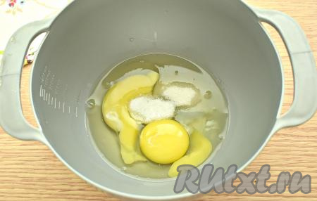 Разбиваем куриные яйца в миску, всыпаем к ним сахар и соль.