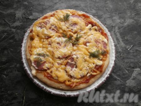 Готовую пиццу с помощью лопатки достать из чаши мультиварки и переложить на тарелку.