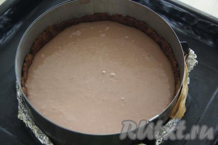 Влить творожно-шоколадную массу в форму для выпечки поверх основы и поставить в разогретую духовку. 