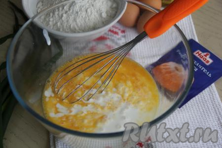 Для того чтобы замесить тесто, нужно вбить в миску яйца, всыпать соль и перемешать яичную смесь венчиком. Затем добавить сметану и влить кефир, перемешать.