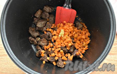 В чашу мультиварки (я готовила в мультиварке Redmond) наливаем растительное масло и включаем на 15 минут режим "Жарка". Как только прозвучит звуковой сигнал, выкладываем в чашу кусочки говядины и обжариваем их при открытой крышке, иногда перемешиваем. За 2 минуты до окончания программы добавляем к обжаренным кусочкам мяса нарезанную на кубики морковь и пропущенный через пресс чеснок, перемешиваем, обжариваем до окончания программы, иногда помешивая.