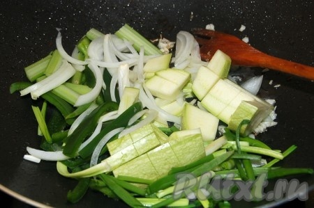 Через 2 минуты в сковороду добавить кабачок, перец сладкий зеленого цвета, сельдерей, зеленый лук.