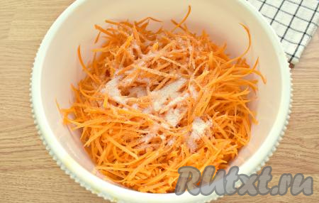 Натёртую морковку выкладываем в миску, всыпаем сахар и соль.