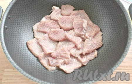 Дно сковороды смазываем растительным маслом. Выкладываем в один слой отбитые кусочки свинины.