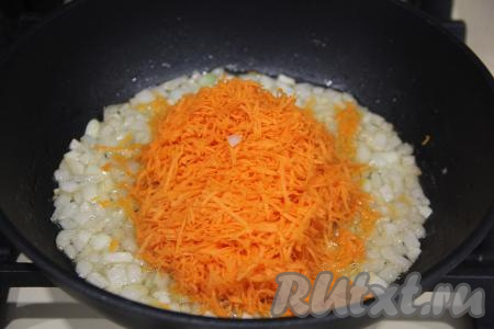 К обжаренному луку добавить очищенную и натёртую на мелкой тёрке морковку, обжаривать, помешивая, 3-4 минуты (до мягкости моркови).