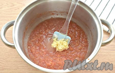 Затем в томатную массу всыпаем сахар, соль, красный молотый перец, добавляем  натёртый на мелкой тёрке чеснок, перемешиваем.