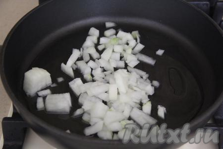 Влить в сковороду с высокими бортиками растительное масло, хорошо прогреть его, а затем выложить нарезанный лук и на среднем огне обжаривать его, помешивая, минуты 3-4.