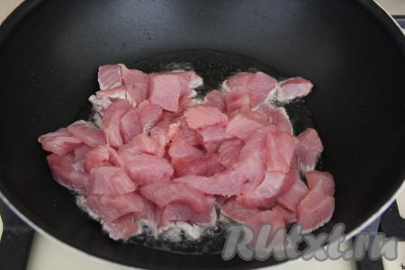 В сковороду с высокими бортиками (можно взять и сковороду вок) влить немного масла, затем выложить индейку, нарезанную на средние кусочки.