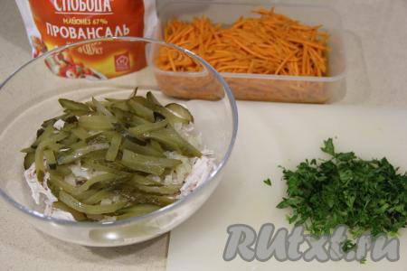 В салат из куриного мяса и лука выложить маринованные огурцы и мелко нарезанную зелень.
