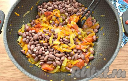 Через 15 минут выкладываем к овощам варёную красную фасоль, вливаем столовый уксус, перемешиваем и протушиваем, помешивая, ещё 5 минут.