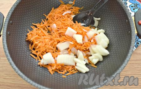Очищаем морковку, чеснок и лук. В глубокую сковороду (сотейник или казан) наливаем растительное масло, выкладываем морковку, натёртую на крупной тёрке, и нарезанный на четверть кольца лук, обжариваем на среднем огне минут 5, помешивая.