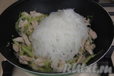 Нарезать фунчозу ножницами на более короткие части и добавить в сковороду к курице и овощам.