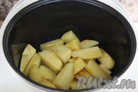 В чашу мультиварки влить растительное масло и выставить режим "Жарка". Картошку нарезать крупными дольками, выложить в чашу и жарить, примерно, 10 минут (до золотистого цвета), периодически помешивая. Затем переложить картошку на тарелку, накрыть крышкой (или глубокой тарелкой).