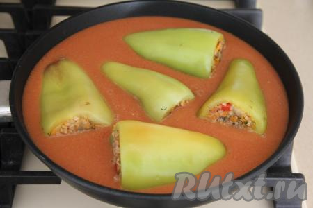 Влить томатный соус в сковороду (или в кастрюлю) с фаршированными перцами, накрыть крышкой и поставить на огонь.