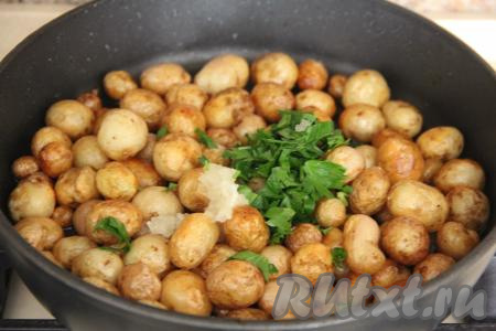 В конце обжаривания картошечку посолить по вкусу, затем добавить чеснок и зелень.