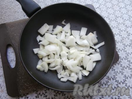 Лук нарезать на средние кусочки, поместить в сковороду, влить 1 столовую ложку растительного масла.