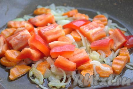 Болгарский перец очистить от семян и перегородок, промыть, нарезать на некрупные кубики и добавить в сковороду к луку и моркови.