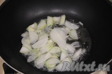В глубокую сковороду влить масло, выложить лук, нарезанный на тонкие полукольца, обжарить его на среднем огне, помешивая, в течение 3-4 минут.