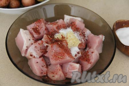К кусочкам свинины добавить соль, пропущенный через пресс чеснок и специи, перемешать.