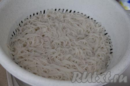 Готовую рисовую лапшу откинуть на дуршлаг, затем хорошо промыть её холодной водой и оставить на пару минут, чтобы убрать лишнюю воду.