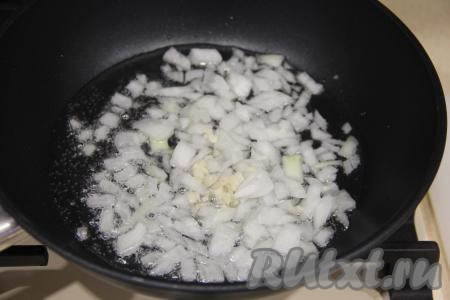 В сковороду влить масло, выложить мелко нарезанные лук и чеснок, обжаривать их на среднем огне минуты 3-4, иногда помешивая.